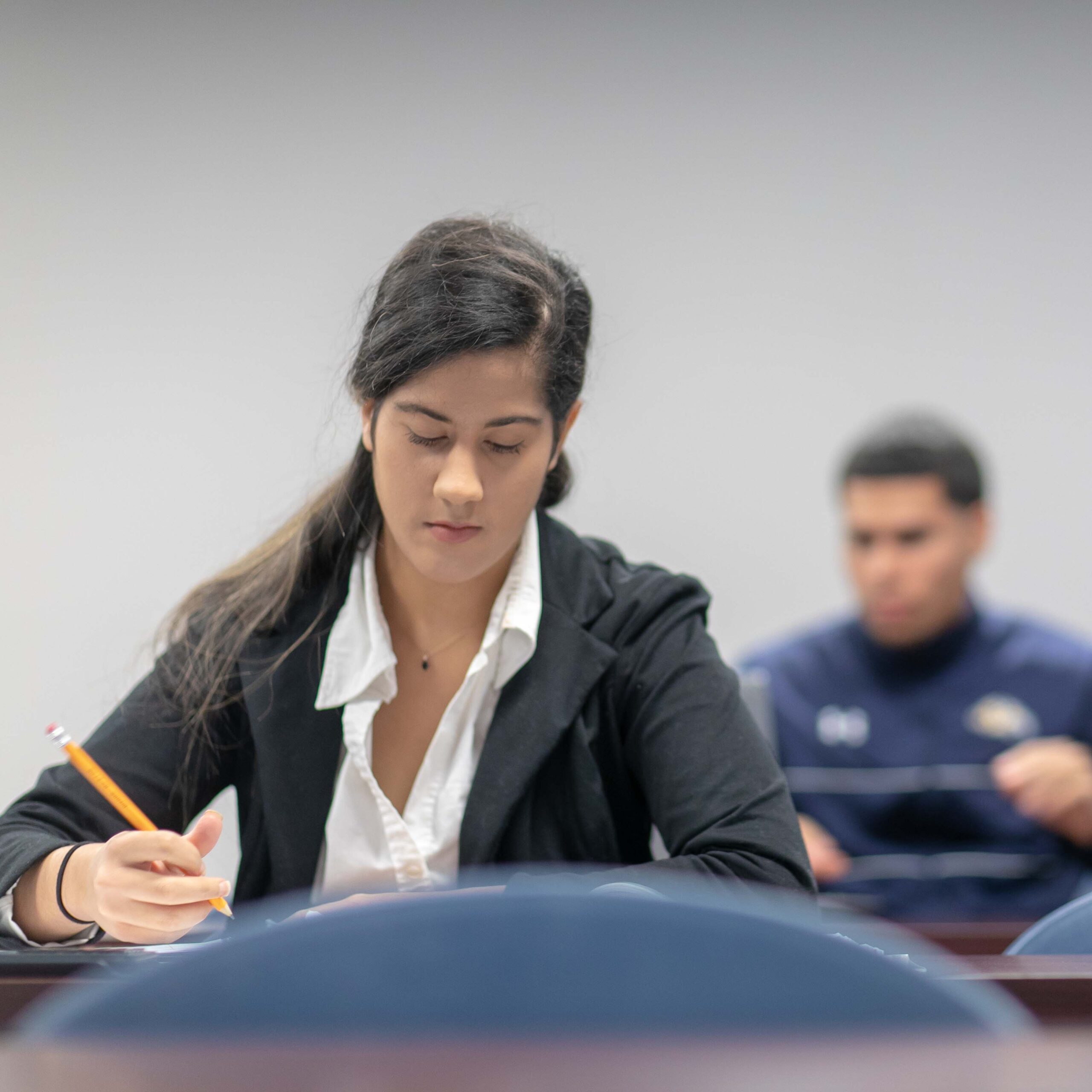 A student wears a blazer to class for a presentation on business administration management.